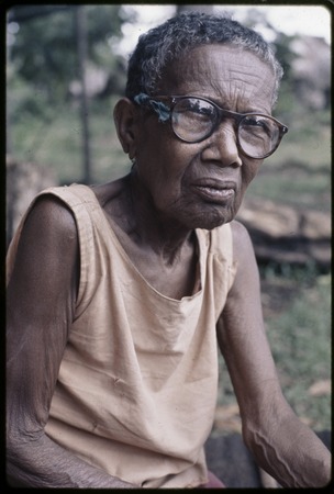 Bomtavau, an older woman, wearing glasses