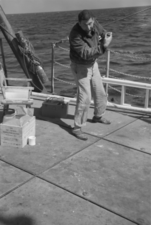 [Man on deck of R/V Spencer F. Baird throwing a TNT charge for seismic profiling]