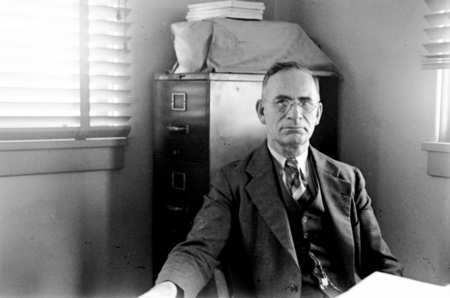 George Francis McEwen seated in his office