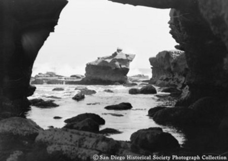 View through rock arch of ocean surf and rock formations at La Jolla