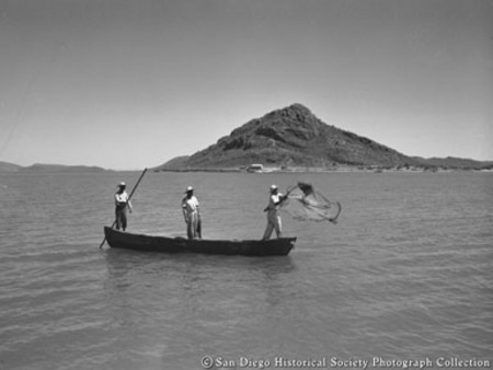 Fishermen casting net from small boat off coast of Baja California