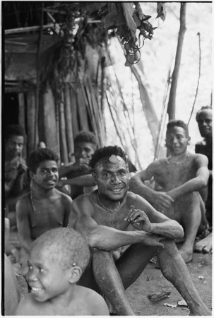 Bomagai: luluai (government-appointed leader) and other men and boys sit and smoke