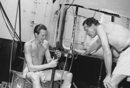 Gustaf Arrhenius (seated) and Roger Revelle examine a drill core, aboard R/V Spencer F. Baird