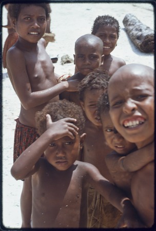 Children on the beach at Kaibola, several girls with heads shaved as a sign of mourning
