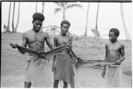 Man and two boys holding captured bats