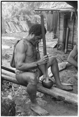 Pounding taro in preparation for ritual before mortuary feast.