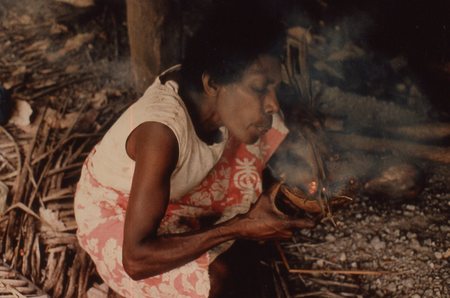 Nevinbong starts a cooking fire using coconut shell and dry grasses
