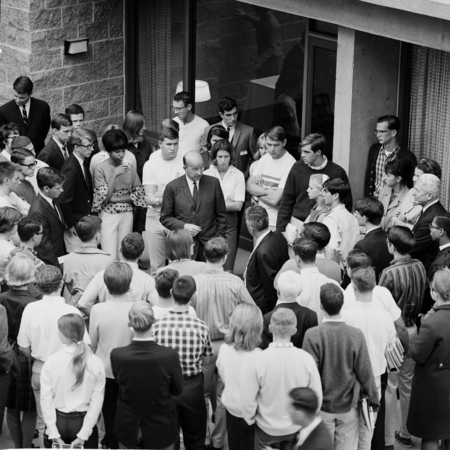 Clark Kerr, Edward Goldberg (back to camera), and John S. Galbraith (at right) in discussion within group of students and ...