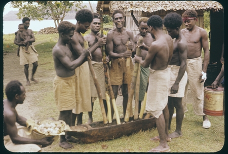 Men mashing up taro root