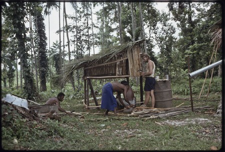 Men, including Edwin Hutchins, construct a hen house