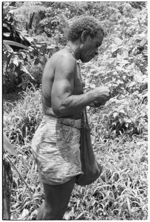 Larikeni talks to his ancestors with a betel nut, areca, and then eats it.
