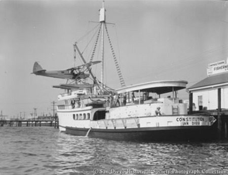 Hoisting seaplane on to stern canopy of tuna boat Constituion