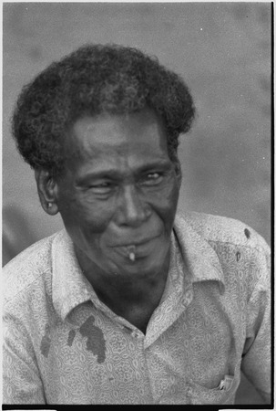 Older man, Motabasi, smoking and smiling for the camera