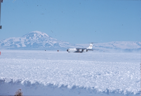 Lockheed Starlifter C141 airplane with Mount Discovery in background, on airstrip at McMurdo Station, Antarctica