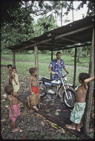 Children watch Edwin Hutchins with motorcycle