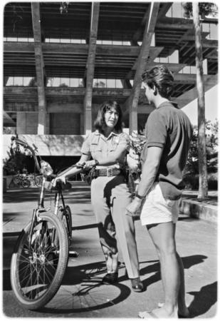 Campus police officer checking bicycles in front of Geisel Library