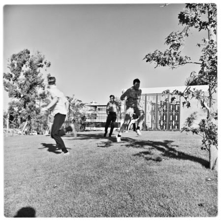 Students playing football on lawn outside Urey Hall