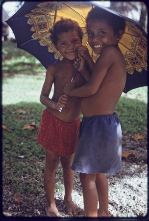 Smiling children under an umbrella