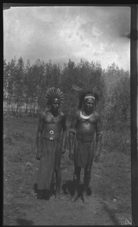 Men with feather head pieces, and a crescent shell valuable necklace called kina, on Gaorbari Island