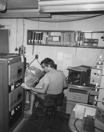 Scientist John W. Ladd of the University of Texas working on state of art computer in the paleo laboratory on board the re...