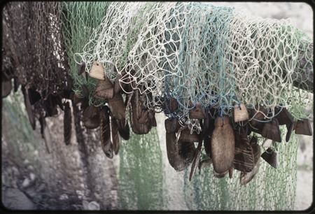 Fishing: nets with hand-carved wooden floats, some shaped like small fish