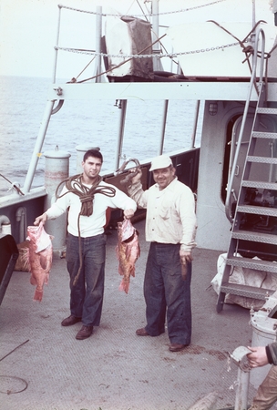 Two members of the crew showing off their fishing catch on the deck of R/V Horizon during the MidPac expedition. 1950.