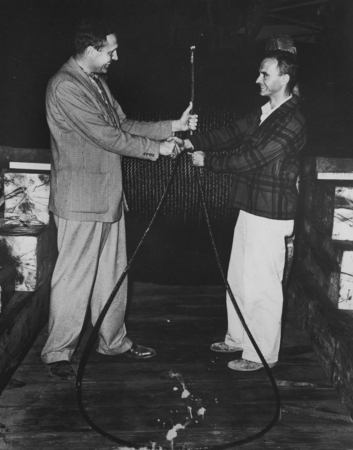 Roger Revelle and Jeffery Frautschy hold wire cable delivered to R/V Spencer F. Baird, on the eve of the departure of the ...