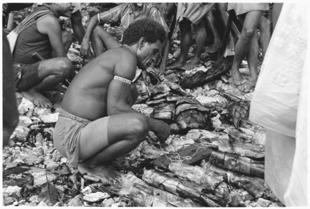 Larikeni of Furingudu measuring out kofu shell money to purchase packets of fish at market with sea people.