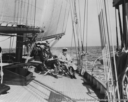Two men sitting on deck of yacht Sartartia