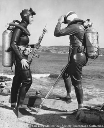 Divers Glenda McLean and Chuck Boswell in wet suits with spear guns