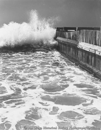 Ocean waves crashing into pier