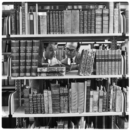 Dr. Gian-Roberto Sarolli, left, and librarian Ronald Silvera de Braganza examine rare books in the Undergraduate Library