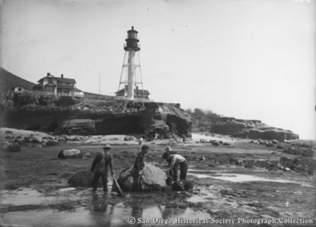 Point Loma Lighthouse, people searching tide pools in foreground
