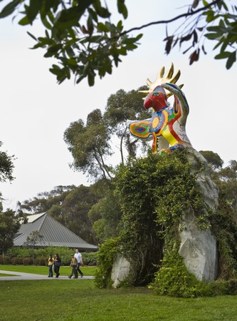 Sun God: general view of sculpture and vine-covered arch with Faculty Club and eucalyptus grove in background