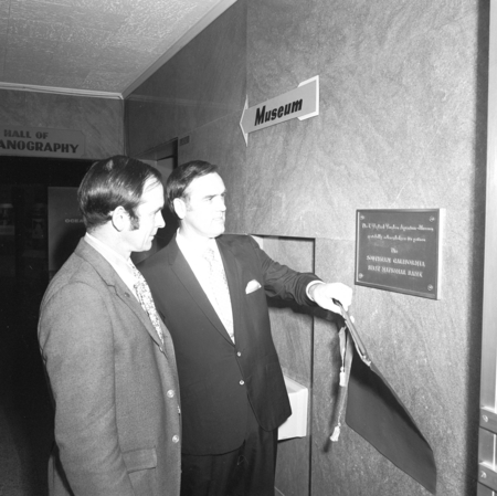 Donald Wilkie and representative of the Southern California First National Bank with plaque in T. Wayland Vaughan Aquarium...