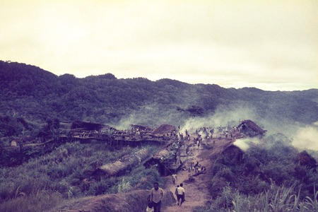 A view of Kerabi hamlet during a pig ceremony, temporary visitor accommodations and earth ovens visible in center