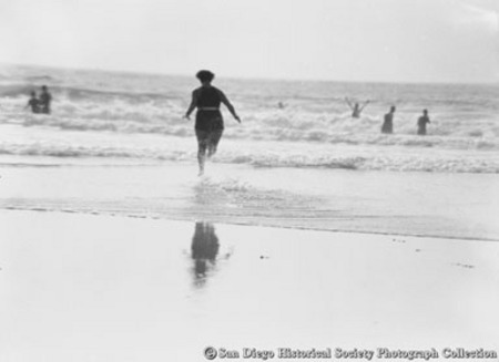 Woman running into ocean surf