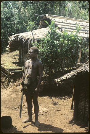 Man standing in front of building with machete.