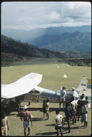 Tabibuga airstrip, people gathered around a small airplane