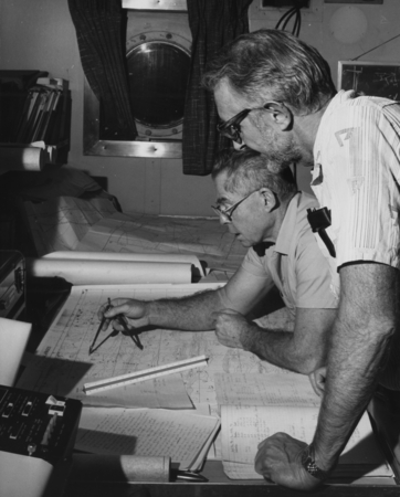 Plotting a course to another drilling site is Joe Clarke (sitting), captain of the D/V Glomar Challenger (ship) of the Dee...