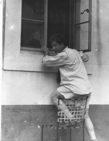 Walter Munk climbing through a window, on the campus of California Institute of Technology