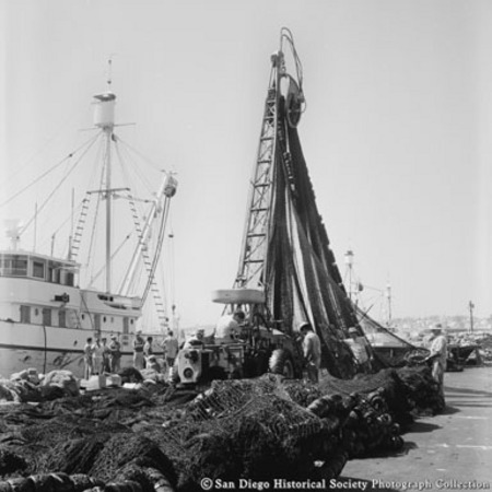 Crane lifting fishing nets on dock