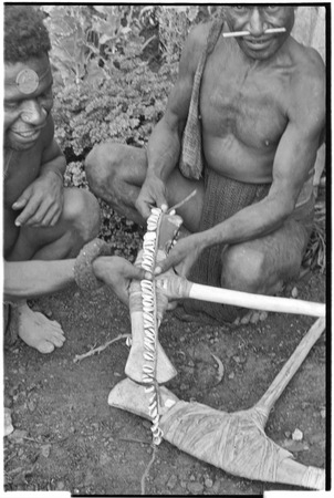 Ritual exchange: men measure strand of cowrie shells against stone axe