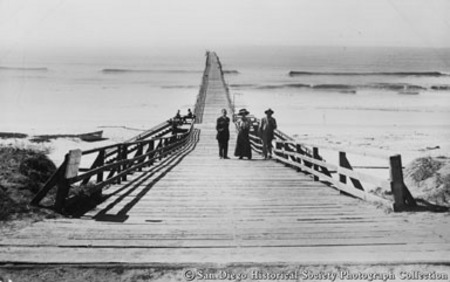 Two men and woman posing on pier at Oceanside beach