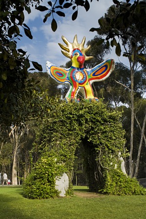 Sun God: general view of front of sculpture and supporting, vine covered concrete arch