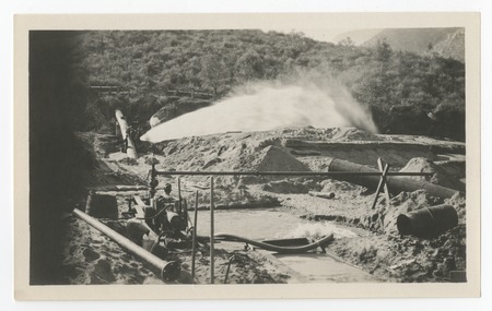 Water spray from a pipeline outlet on the San Diego flume, under construction following the 1916 flood