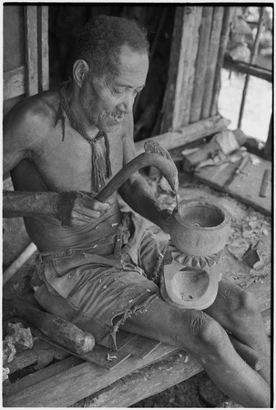 Carving: M&#39;lapokala uses a decorated adze to carve a wooden bowl with stand, probably for tourist trade