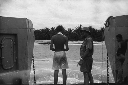 Oceanographer Norman J. Holter (man in hat), with two other unidentified men, who has just landed on Bikini Island using a...