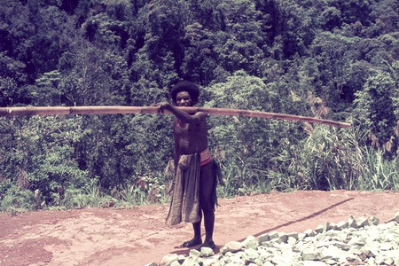 Carrying a bamboo tube filled with palm oil, an item in ceremonial trade