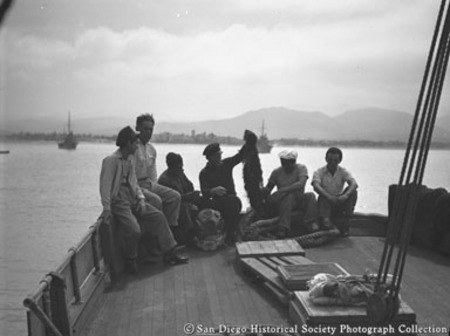 Men sitting on stern deck of American Agar Company boat